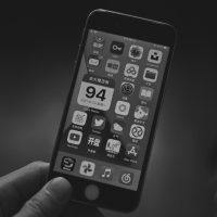 black iphone 4 turned on displaying icons