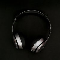 silver headphones on top of black surface